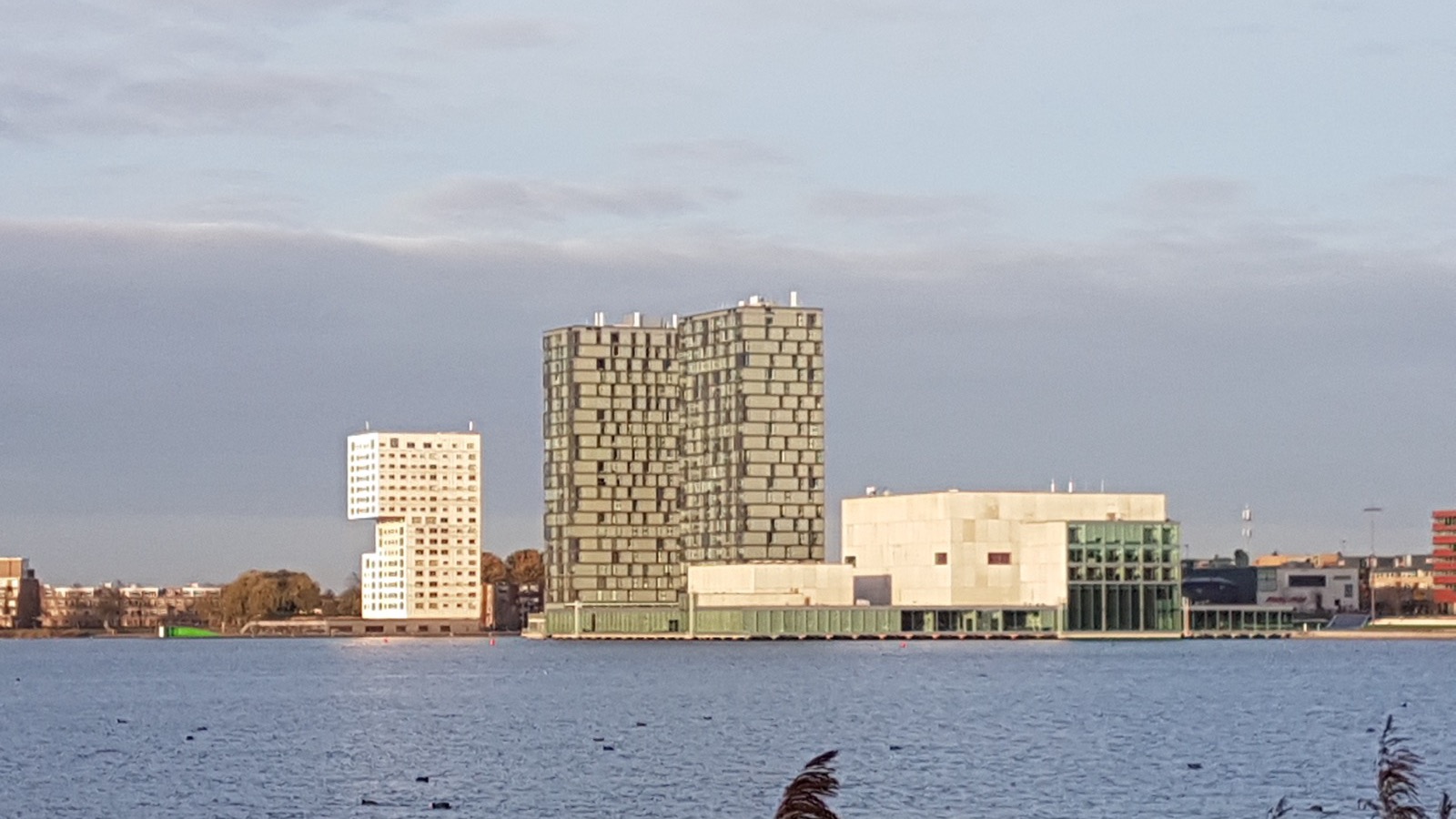 De skyline van Almere Stad met de woontorens en de Kunstlinie aan het Weerwater in laag zonlicht.